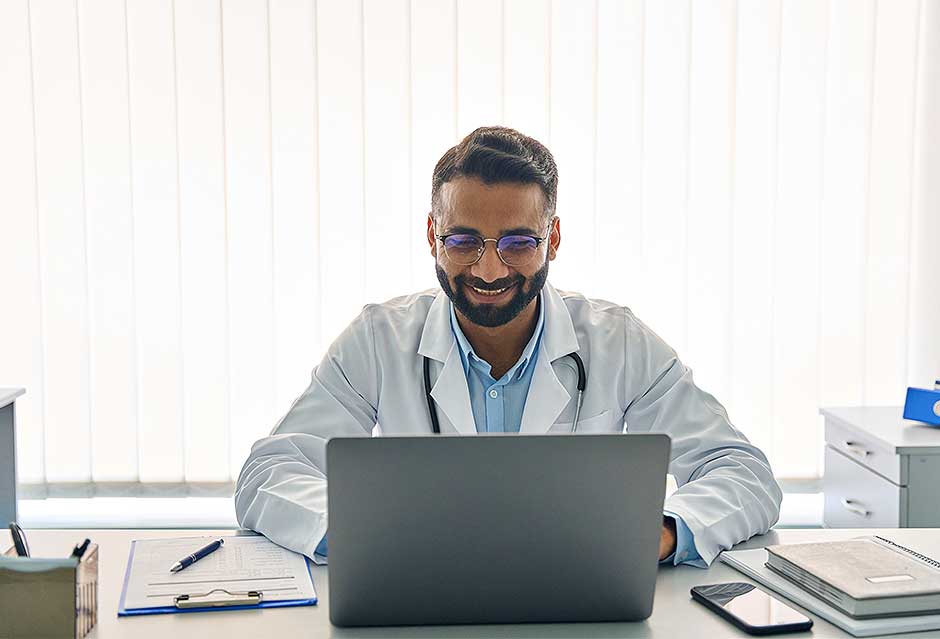 doctor on laptop smiling